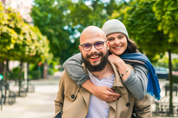 Cheerful young couple embracing and smiling at camera
