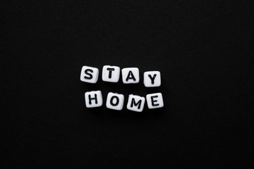 Stay Home, Word written by Cube letters, Stop Corona Virus, Message for people white cubes on a black background, no person, space for text and horizontal