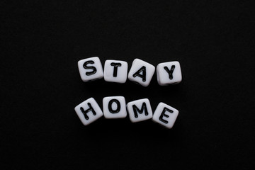Stay Home, Word written by Cube letters, Stop Corona Virus, Message for people white cubes on a black background, no person, space for text and horizontal