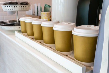 Disposable plastic cups standing in a row for display in shop.
