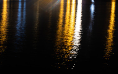 Colorful light reflection on the water surface at night.