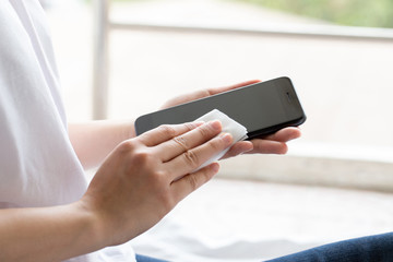Woman cleaning the phone by alcohol pad for clean phone and technology to prevent corona virus covid-19 © Pcess609