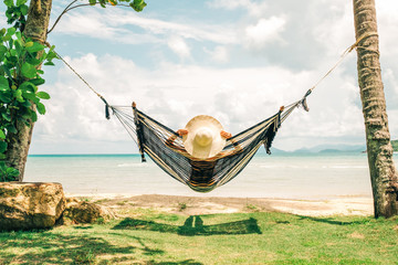 Happy woman in black bikini relaxing in hammock - Powered by Adobe