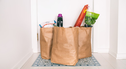 Grocery online delivery receiving grocery bags at home entrance door outside doorstep hallway...