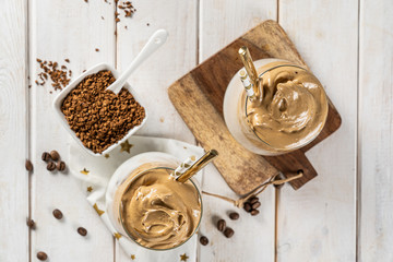 Coffee trend - dalgona coffee, whipped instant coffee on rustic background, copy space