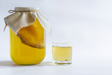Kombucha Healthy natural probiotic drink in a glass jar and a glass. On a white background with space for text.