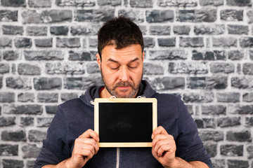 man holds chalkboard in his hands