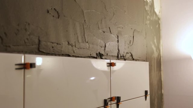 Worker putting tile glue on wall