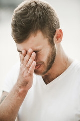 Fototapeta premium smiling friendly guy with a variety of emotions; a man in a white T-shirt and jeans with a clock on his hand;