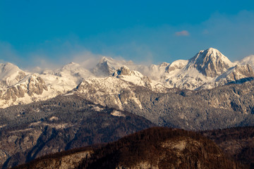 Julian alps covered in morning mist, view from Bohinj, Slovenia
