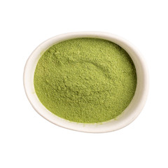 Organic wheatgrass powder in white bowl isolated on white background. Top view, close-up.  Green...