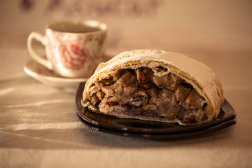 close up of an Apple strudel with hot tea under the Morning light.