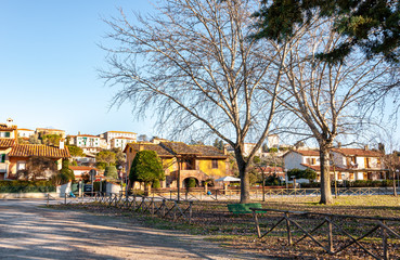 Fototapeta na wymiar Castiglione del Lago, Umbria, Italy. Medieval village that rises on a promontory on Lake Trasimeno. View of the modern part of the city from the lake shore.