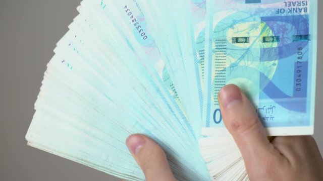 A man is counting money, Israeli shekels