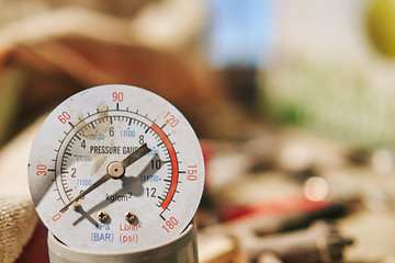 Old broken pressure gauge on a blurred background.