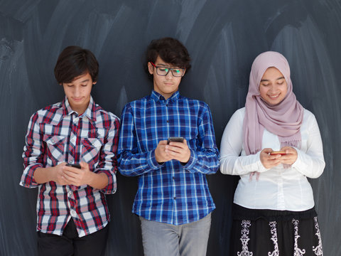 Arab Teenagers Group Using Smart Phones For Social Media Networking