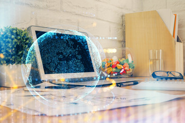 Double exposure of desktop with computer and world map hologram. International data network concept.