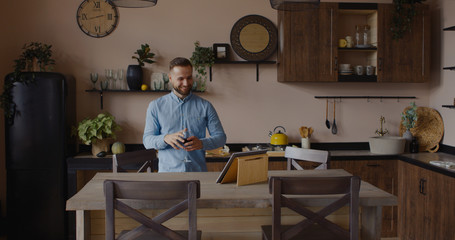 Handsome Caucasian man having a glass of wine during video call with friends or partner. Stay home, quarantine life