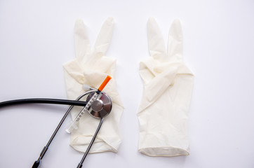 Red heart and syringe and stethoscope on white background, soft focus,