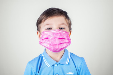 A 7-year-old boy in a medical mask isolated on a white background