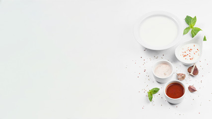 Different types of sauces and spices on a white background.