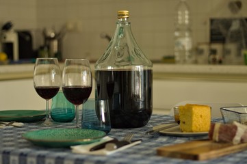 Table set with dishes, glasses and a bottle of red wine near salami and bread (Pesaro, Italy, Europe)