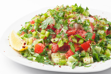 Vegetable salad on a white plate. White background.