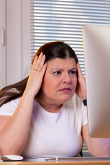 Closeup of a professional woman working at home, She looks preoccupied while looking at the...