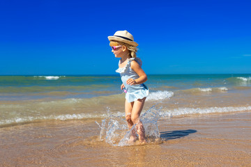 Happy child jumping in sandy beach