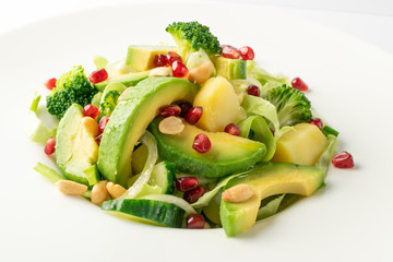 Green Salad with Avocado, Cucumber and Nuts on White Plate