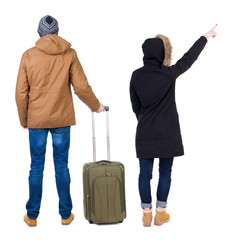 young couple in winter jacket traveling with suitcas.