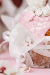 Baked Kulich with Sweet Meringues on Flowing Cream Close-up Photography. Celebrative Christian Backed Dessert Ornamented Blooming Apricot Flower Buds on Textile Pouch. Blurred Background