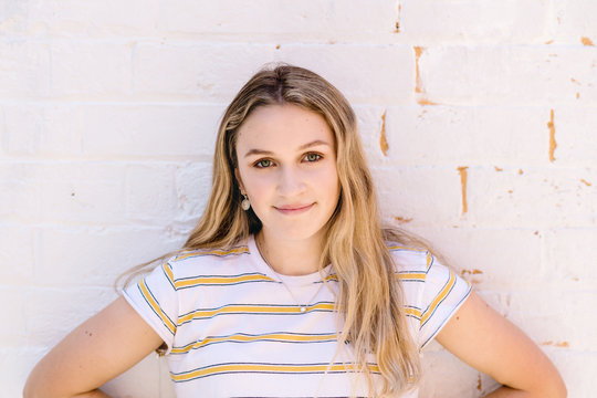 teen standing against brick wall