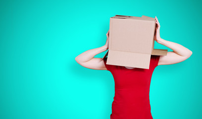 Person with cardboard box holding its head on turquoise background