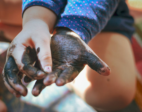 The Child Got His Hands Dirty In Black Nail Polish. Hands Of The Baby In Black Paint. Baby Draws With Hands