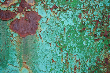 Green peeling paint on a rusty surface
