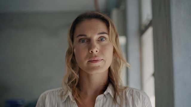 Businesswoman staring at camera while standing in office. Female entrepreneur with a blank facial expression.
