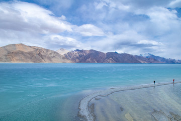 View landscape of Himalayas mountains and Frozen lake Pangong Tso high grassland lake while winter season for indian and tibetan and foreigner travelers travel visit at Leh Ladakh, India.
