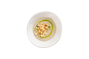 champignon mushroom cream soup in white bowl with bread croutons isolated on white background