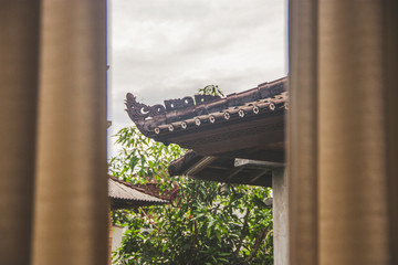 Asian roof details behind curtains
