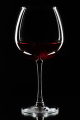 Wine glasses of different shapes and a bottle on a black background. A contour photo.