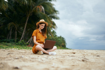 woman with laptop on the beach