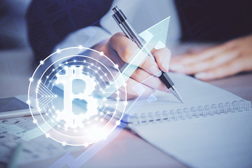 Cryptocurrency hologram over woman's hands writing background. Concept of blockchain. Multi exposure