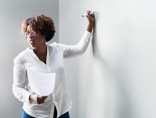 Woman writing on a white wall