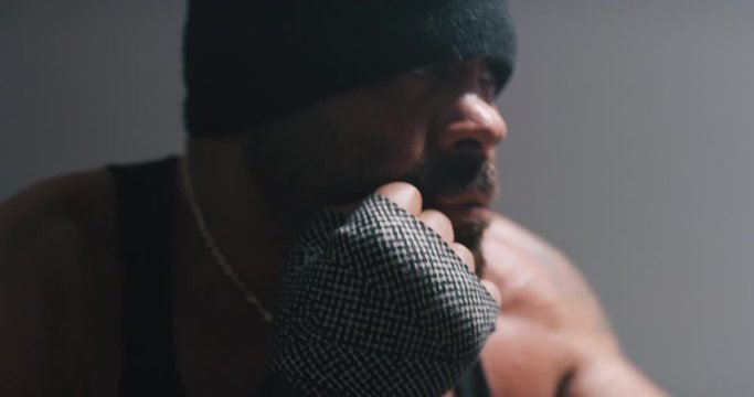 Profile of boxer throwing punches while training.