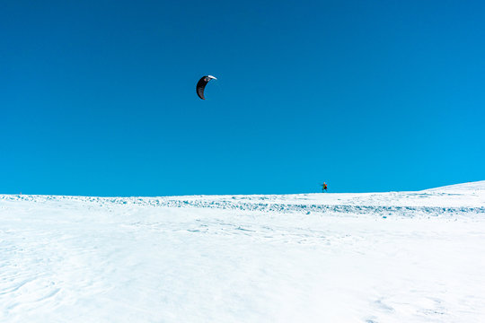 Sport in montagna innevata con paracadute