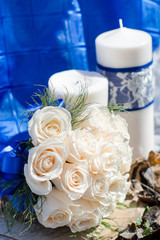 the bride's wedding bouquet of light roses next to candles