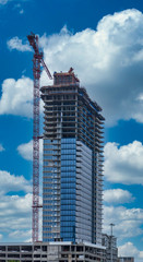 Fototapeta na wymiar New office tower construction with red crane