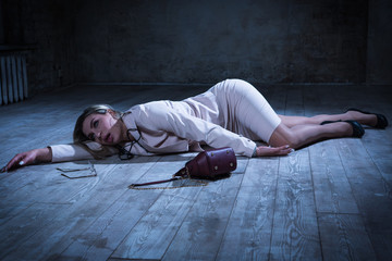 Crime scene with strangled pretty business woman lying on the floor