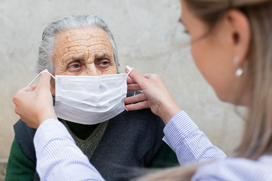 Nurse Putting On Mask On Elderly Woman